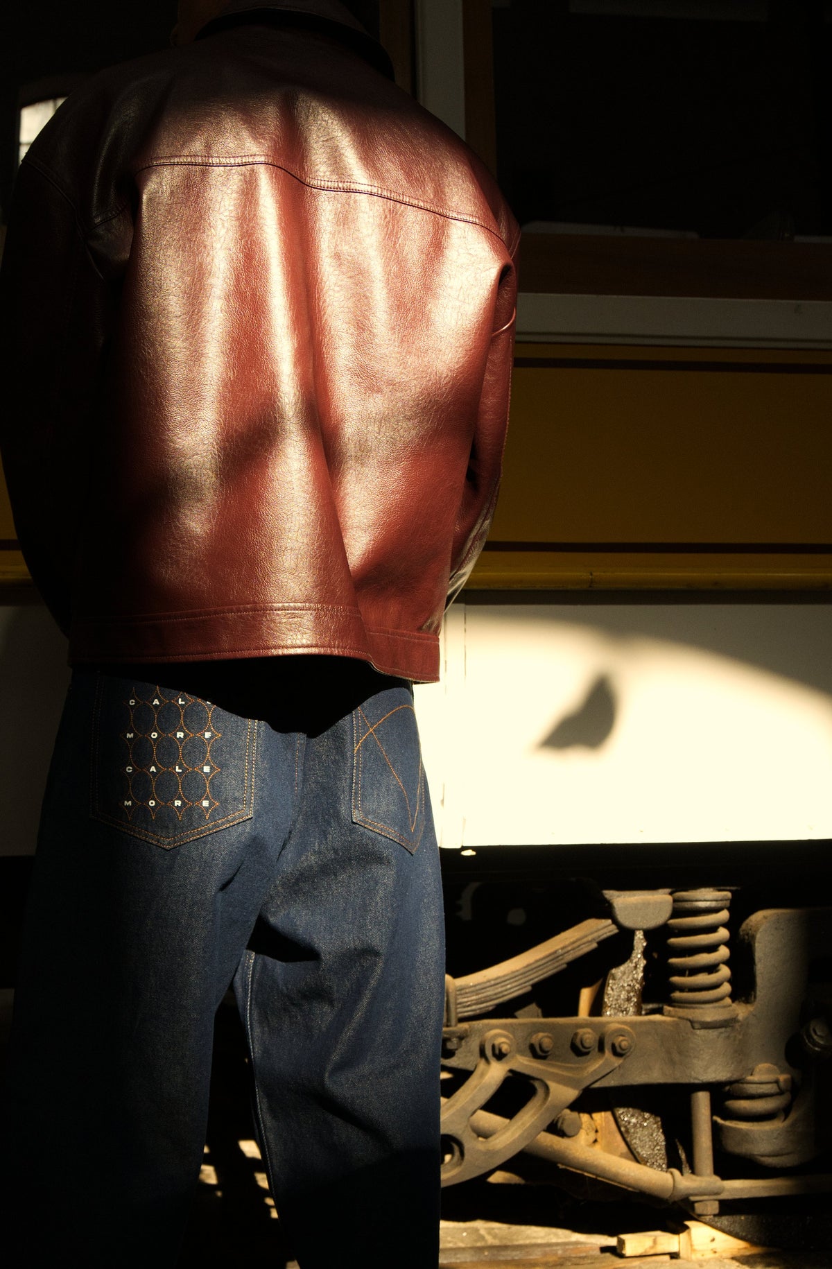 Raw denim trousers from behind, by a tram