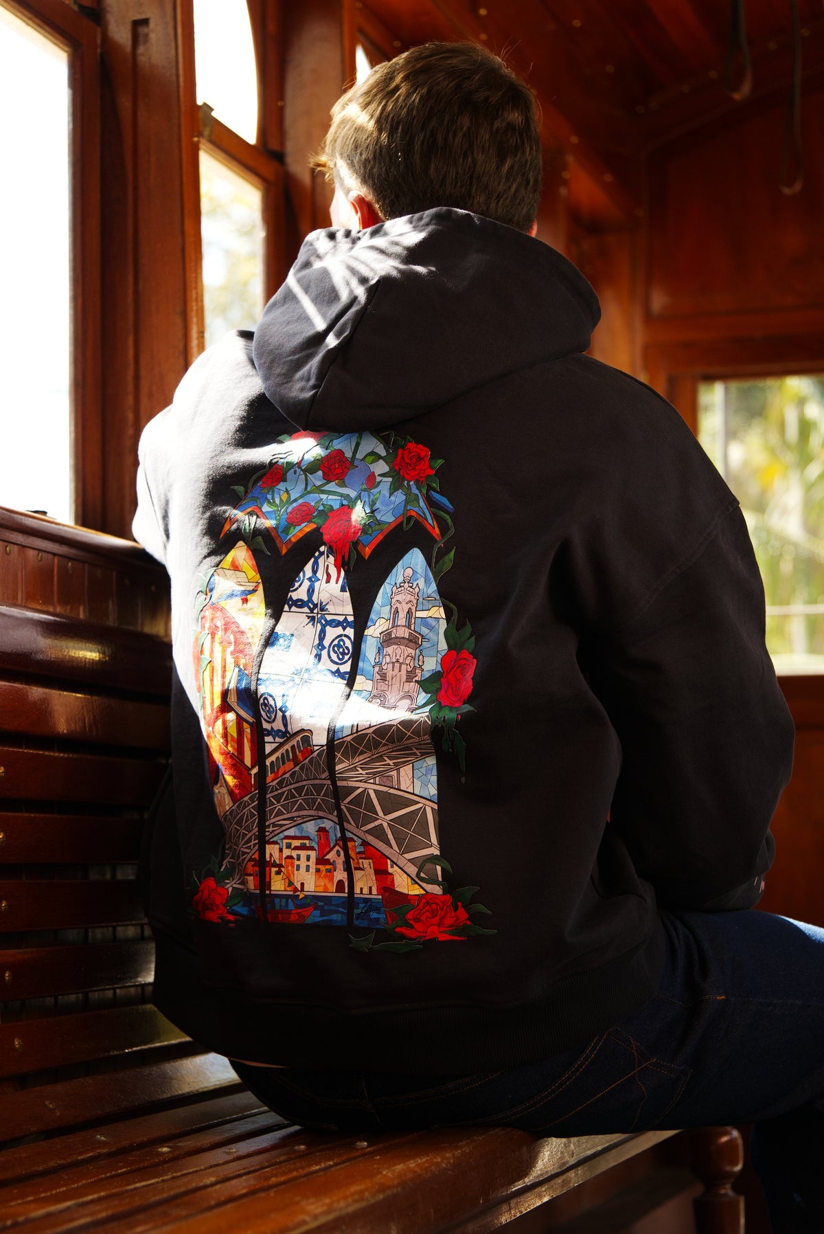 The hoodie’s embroidered back, in a wooden Porto tram
